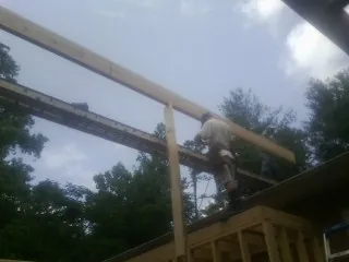 Carpenter setting a ridge beam over a new addition frame — Ice Dam Removal by Roofing Brothers in Bel Air
