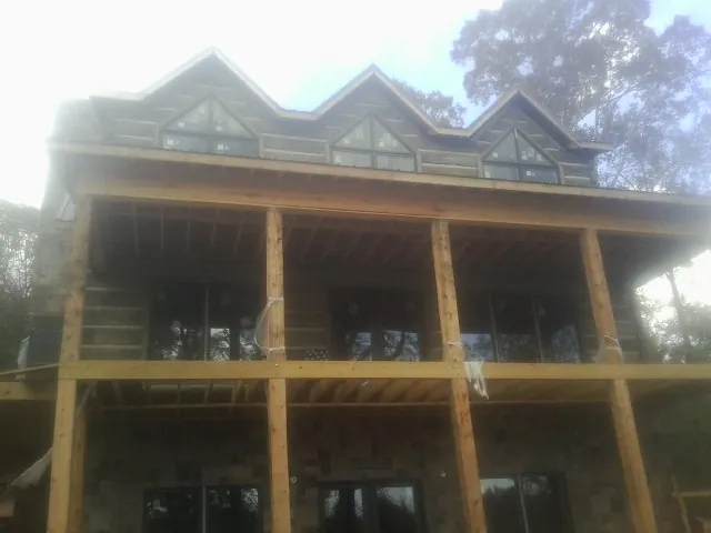 Dormers and porch framing on a large log home under construction — Roof Coating work by our crew in Bel Air