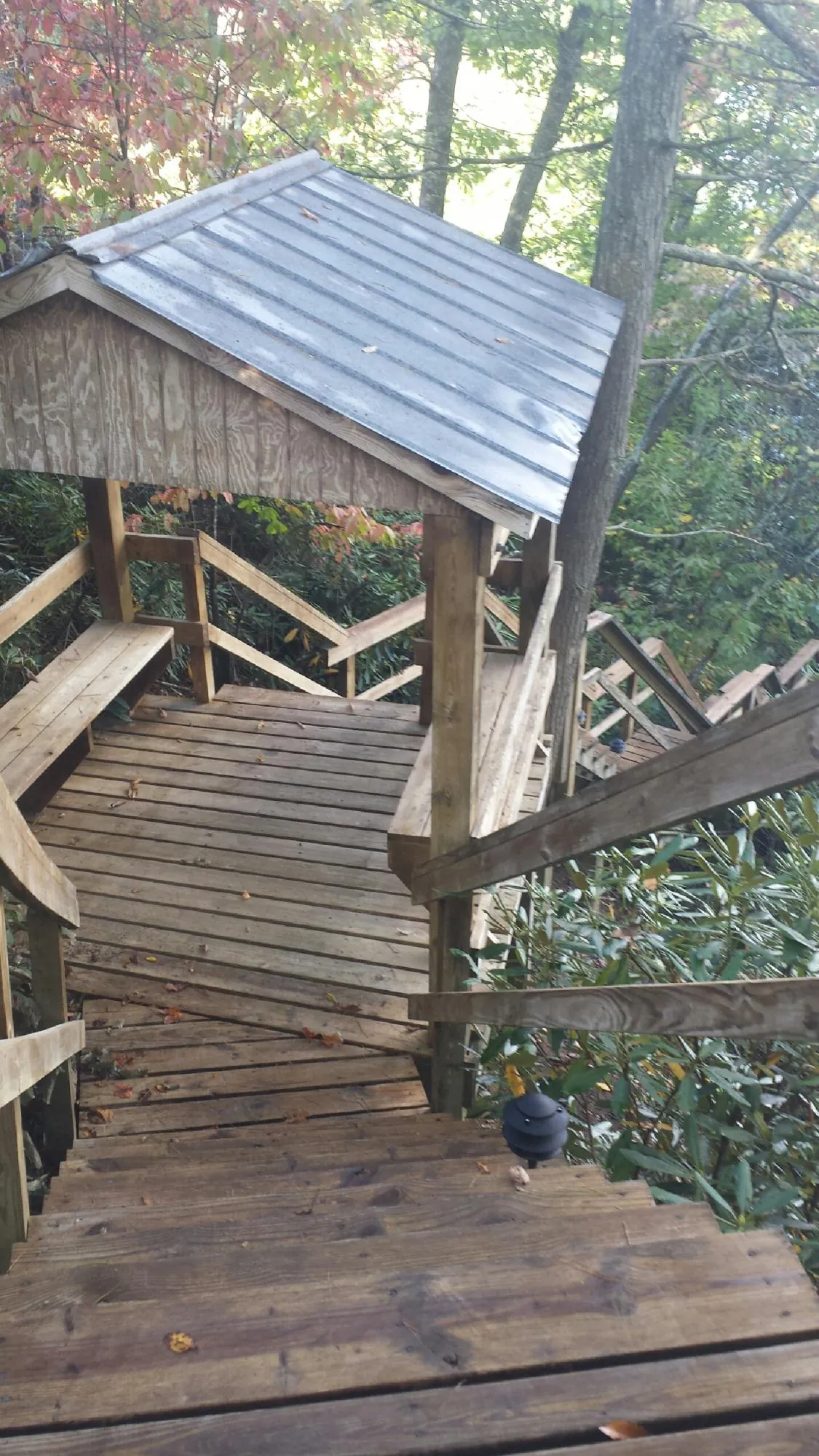 Metal roofed shelter over wooden steps on a wooded walkway — Skylight Repair & Installation work by our crew in Bel Air